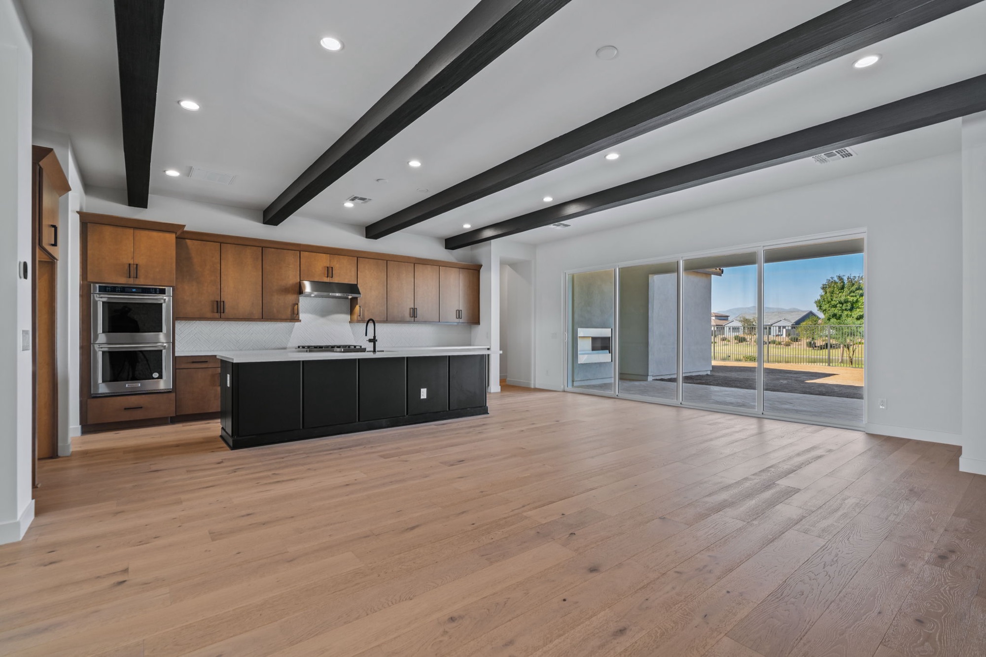 Kitchen with double ovens and stacking sliding glass doors to the patio